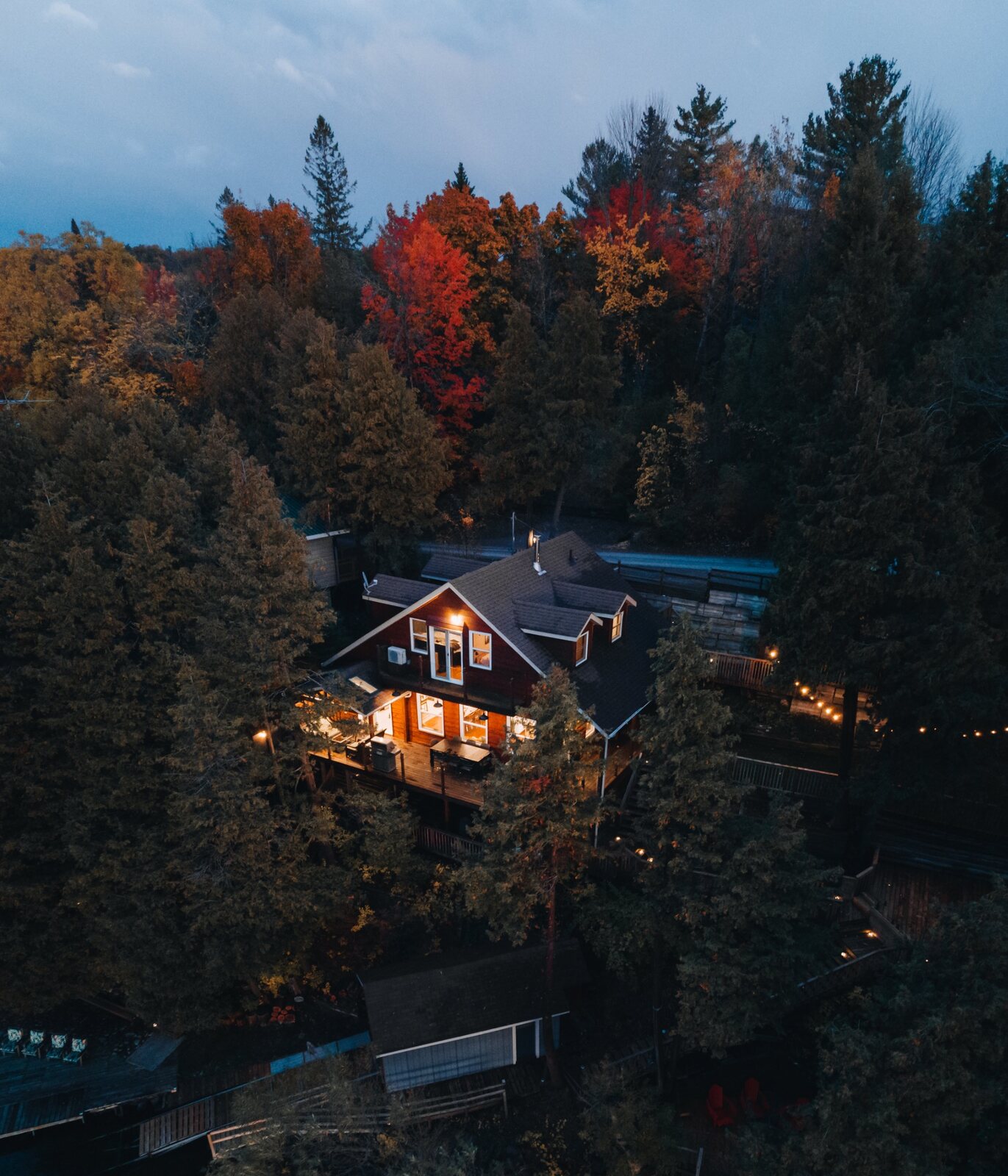Aerial view of Rice Lake Treehouse surrounded by autumn trees at dusk